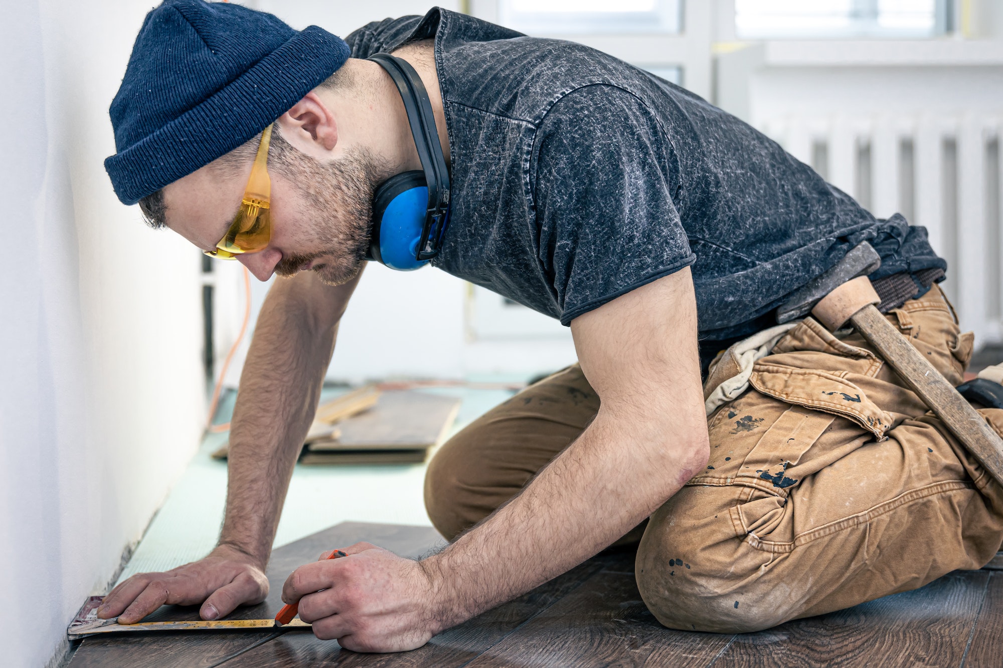 A male worker puts laminate flooring on the floor.