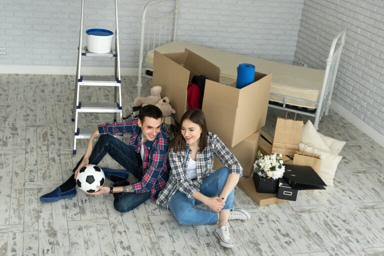 Young couple in a new home relaxing on the background of big boxes. Concept housewarming, began