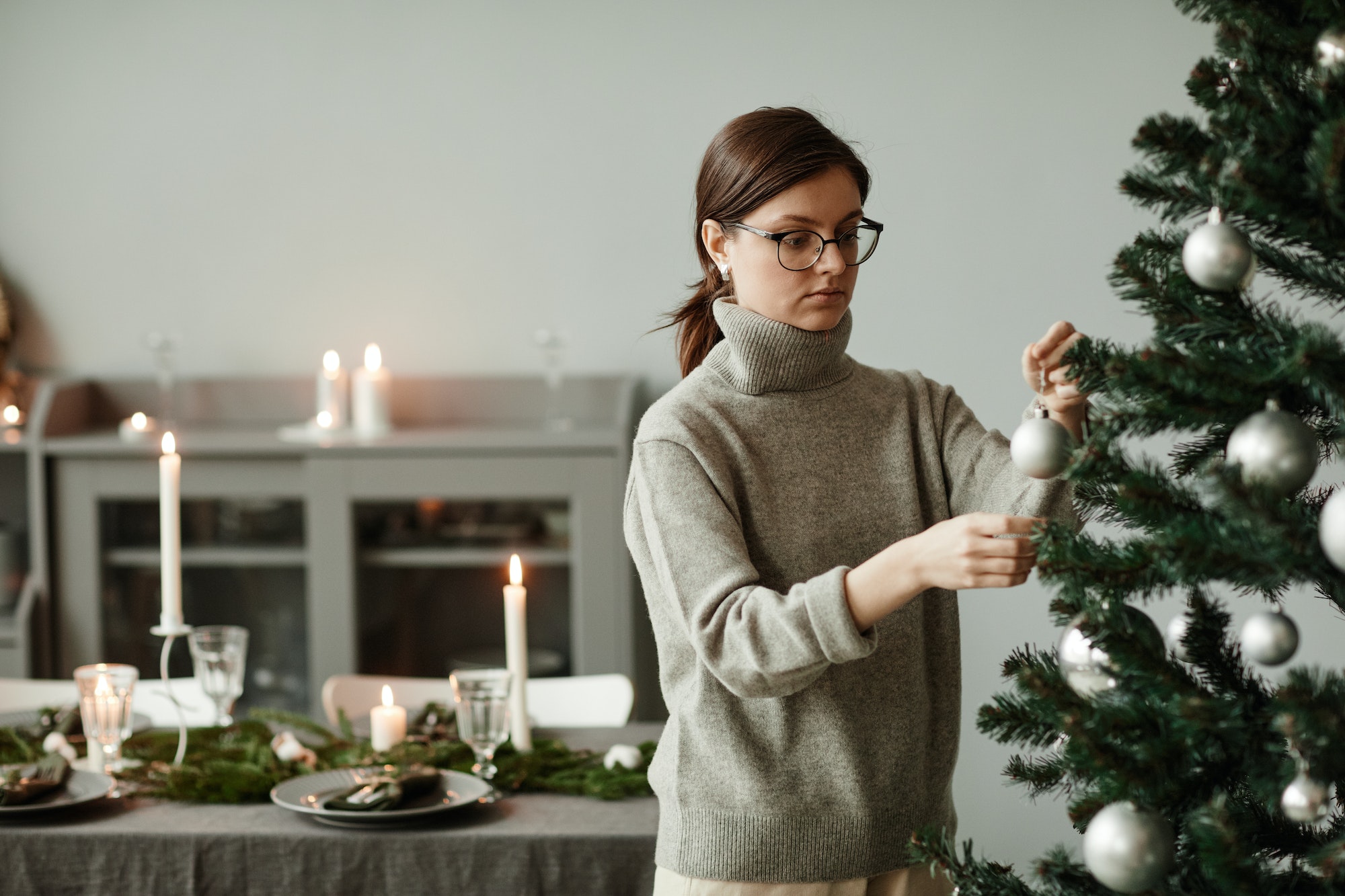 Young Woman Decorating Christmas Tree Minimal